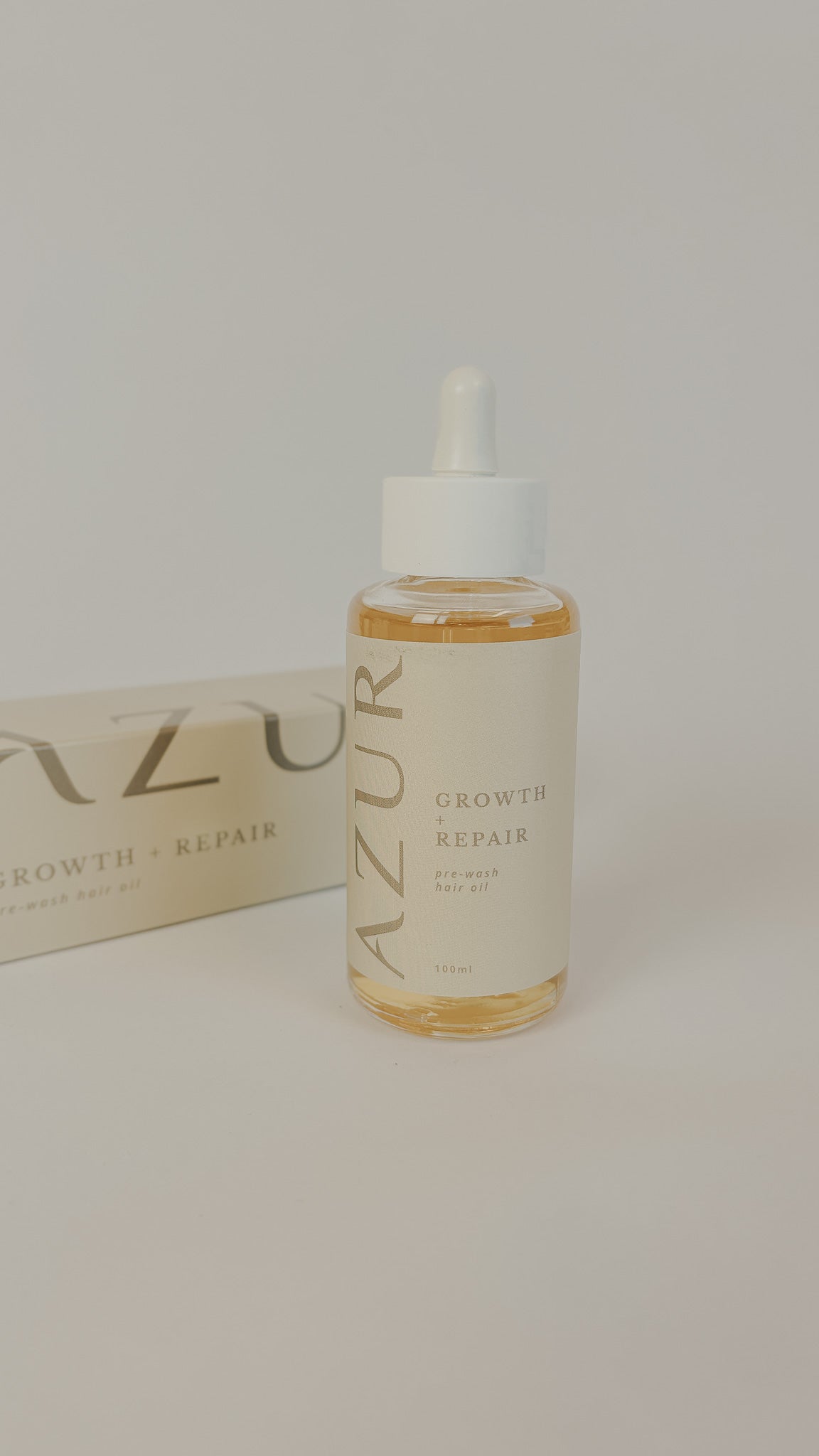 PURELA AZUR Growth & Repair hiusöljy 100ml, lämmöllä hoitava ja ravitseva hiusöljy, näkyvät hiukset ja öljytippoja kuvassa